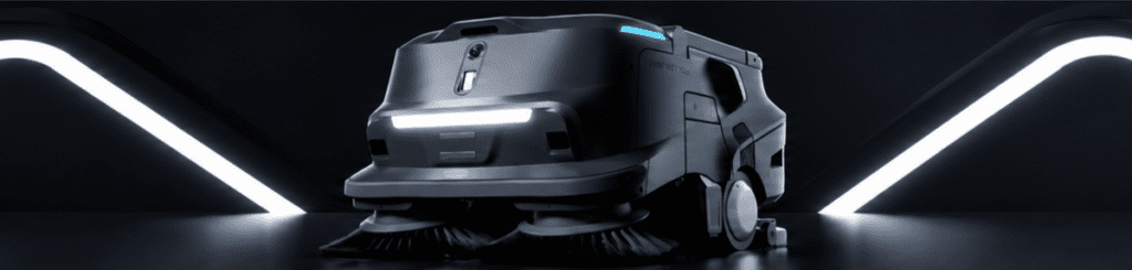 Autonomous SHOP VAC industrial floor-sweeping robot in a futuristic dark studio with glowing LED accents and illuminated wave-shaped background lights.